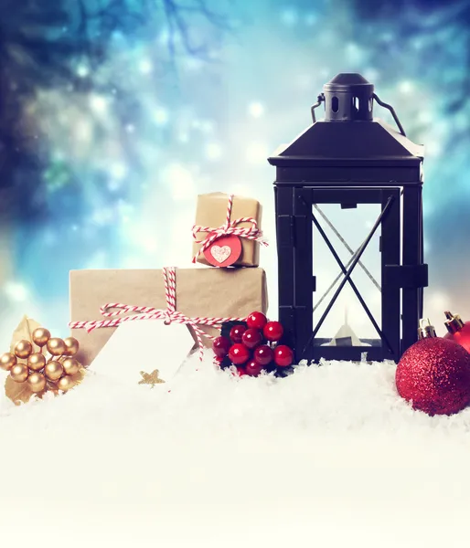 Різдвяний ліхтар з прикрасами на снігу — стокове фото