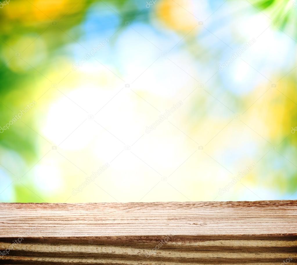 Wooden table over shiny light background