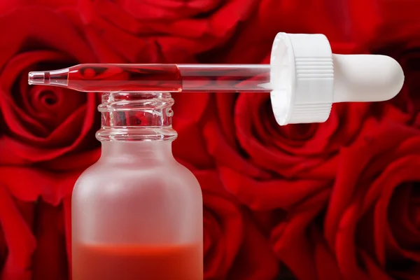 Σταγονόμετρο μπουκάλι με κόκκινα τριαντάφυλλα — Φωτογραφία Αρχείου