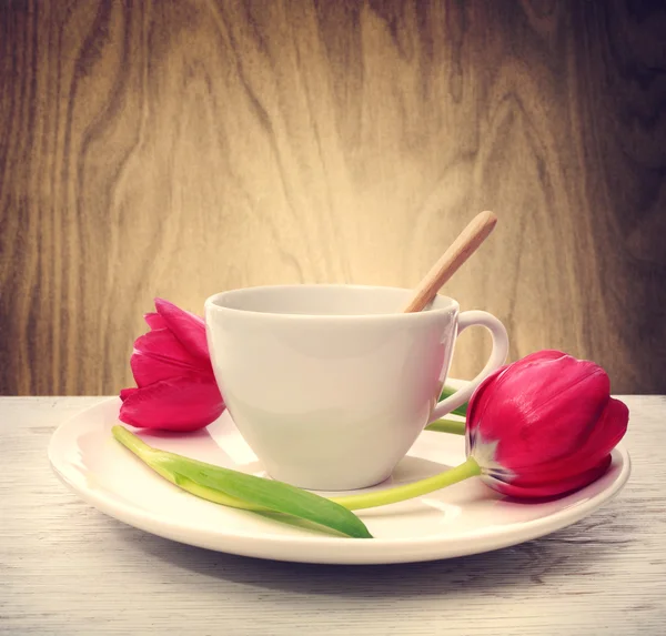Koffiekopje met rode tulpen — Stockfoto