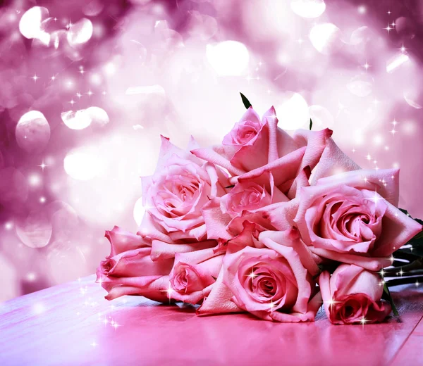 Belas rosas cor-de-rosa na mesa de madeira rosa — Fotografia de Stock