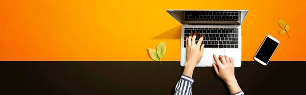 Őszi levelek személy segítségével egy laptop számítógép — Stock Fotó