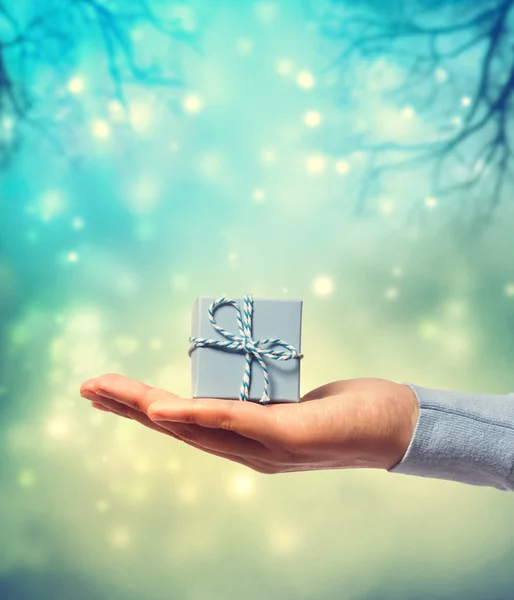 Presentando una pequeña caja de regalo azul — Foto de Stock