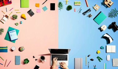 Ofis malzemesi olan bir dizüstü bilgisayar kullanan kişi.