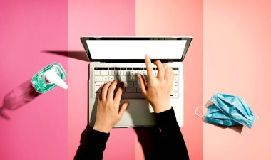 El dezenfektanı ve maskeli dizüstü bilgisayar.