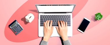 Kumbarası olan dizüstü bilgisayar kullanan bir kadın.