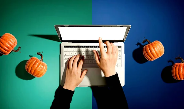 Calabazas de otoño con persona usando un ordenador portátil —  Fotos de Stock