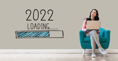 Yeni yıl 2022 'de dizüstü bilgisayar kullanan bir kadınla yükleniyor