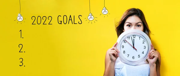2022 mål med ung kvinna som håller en klocka — Stockfoto