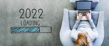 Yeni yıl 2022 'de dizüstü bilgisayar kullanan bir adamla yükleniyor