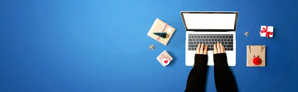 Pessoa usando um computador portátil com caixas de presente de Natal — Fotografia de Stock