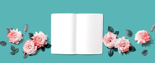 白色空白笔记本，头顶是粉色玫瑰 — 图库照片