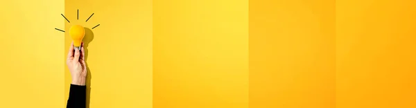 Persoon met een gele gloeilamp — Stockfoto