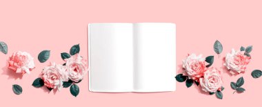 Üzerinde pembe güller olan beyaz boş defter