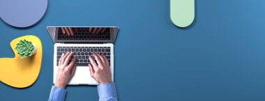 Geometrik şekilli nesneleri olan bir dizüstü bilgisayar kullanan kişi