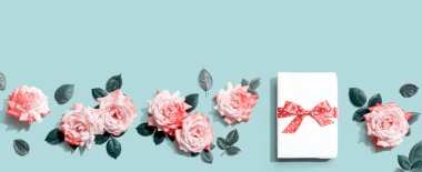 Üstünde pembe güller olan hediye kutusu.