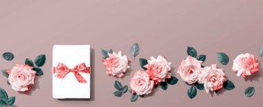 Üstünde pembe güller olan hediye kutusu.