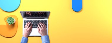 Geometrik şekilli nesneleri olan bir dizüstü bilgisayar kullanan kişi