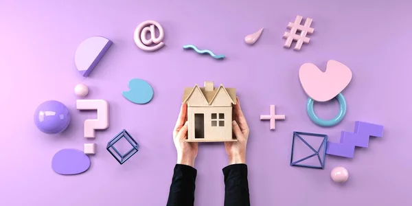 Osoba držící kartonový dům s geometrickými tvary — Stock fotografie