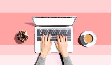 Laptop bilgisayar ve bir fincan kahve kullanan bir adam.