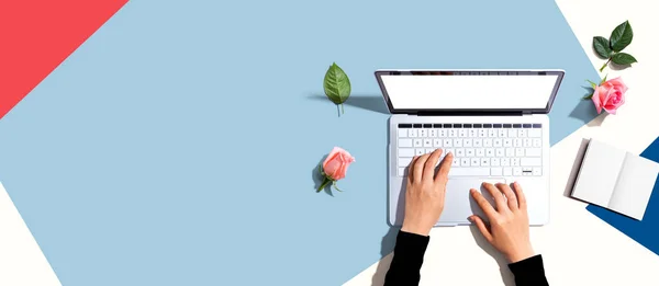 Kobieta korzystająca z laptopa z różowymi różami — Zdjęcie stockowe