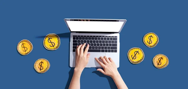 Persoon met behulp van een laptop computer met munten - online thema verdienen — Stockfoto