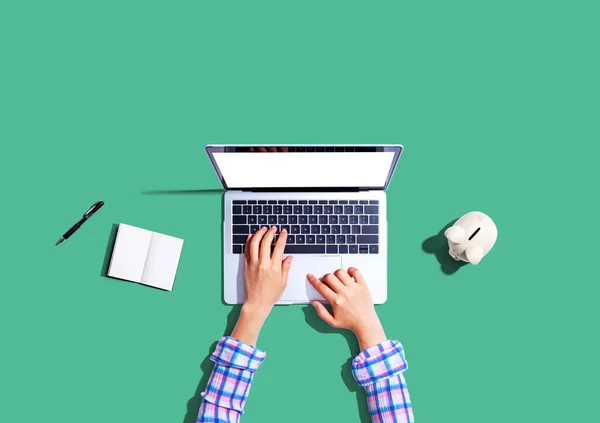 Vrouw met behulp van een laptop computer met een spaarpot — Stockfoto