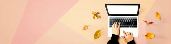 ノートパソコンを使用している人と秋の葉 — ストック写真