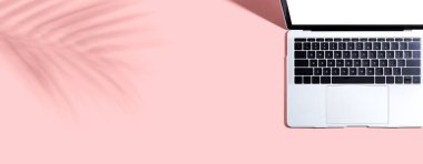 Tropikal yaprağın gölgesinde dizüstü bilgisayar