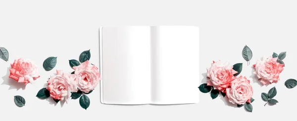 Üzerinde pembe güller olan beyaz boş defter — Stok fotoğraf