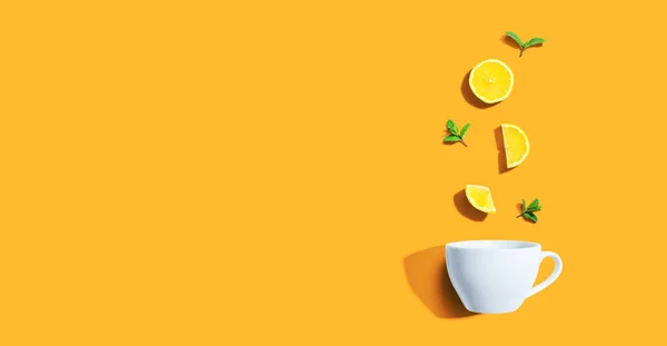 Свежие желтые лимоны с чашкой чая сверху — стоковое фото