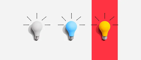 Ideia e criatividade conceito com lâmpadas brancas, azuis e amarelas — Fotografia de Stock