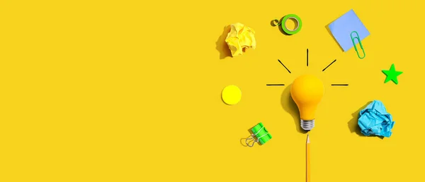 Brainstorming concept with a light bulb and school supplies - Flat lay — ストック写真