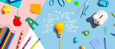 Bir ampul ve okul malzemeleri ile beyin fırtınası konsepti