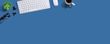 Bir fincan kahve ve gözlüklü bilgisayar klavyesi.