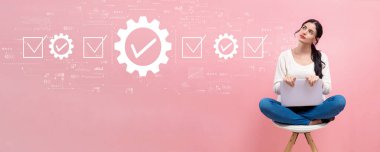 Dizüstü bilgisayar kullanan genç bir kadının kalite kontrol onayı