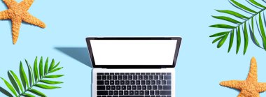 Yazlık palmiye bitkileri ve deniz yıldızlı dizüstü bilgisayar - düz yatıyordu