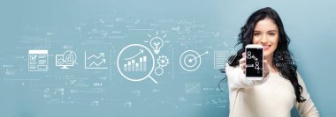 Elinde akıllı telefon tutan genç bir kadının veri analizi konsepti