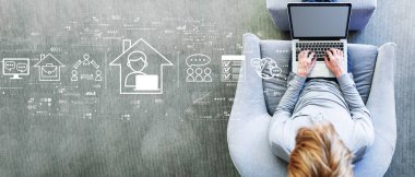 Modern gri sandalyede dizüstü bilgisayar kullanan bir adamla uzaktan çalışma teması