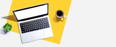 Yukarıdan kahve fincanı olan bir dizüstü bilgisayar.