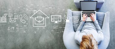 Telework theme with man using a laptop in a modern gray chair