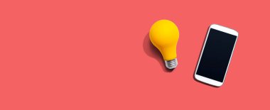 Yukarıdan sarı ampullü akıllı telefon.