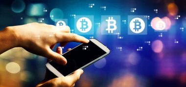 Akıllı telefon kullanan kişi ile Bitcoin teması