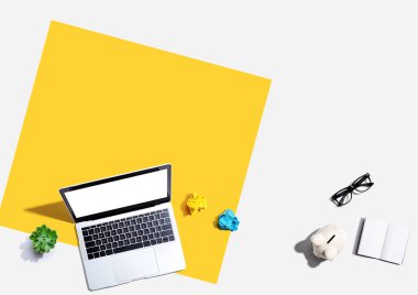 Domuz kumbarası ve ofis eşyalarıyla dizüstü bilgisayar - düz konum