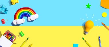 Gökkuşağı ve okul gereçleri manzaralı bir ampul.