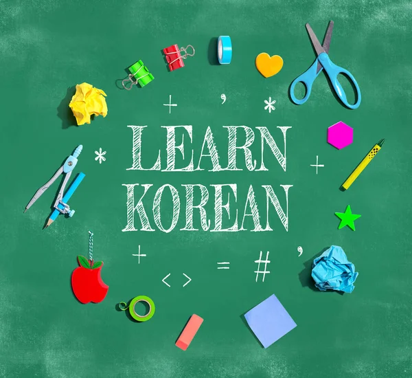 Learn Korean theme with school supplies on a chalkboard - flat lay