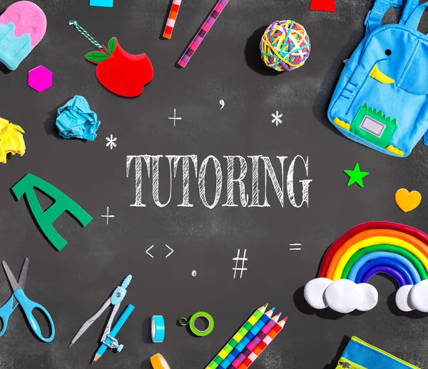 Tutoring theme with school supplies on a chalkboard - flat lay