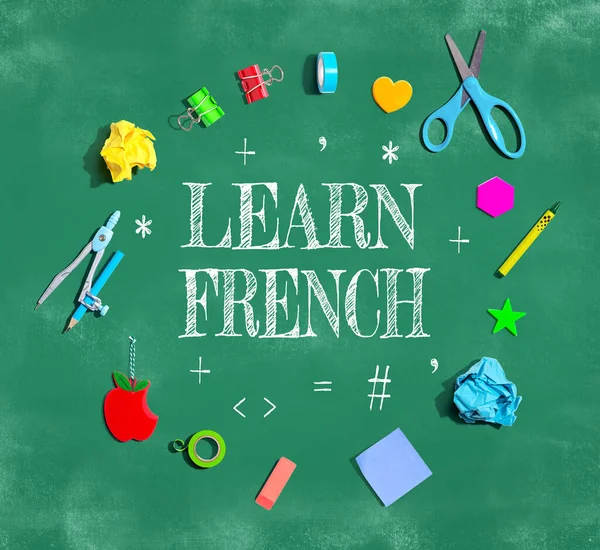 Learn French theme with school supplies on a chalkboard - flat lay