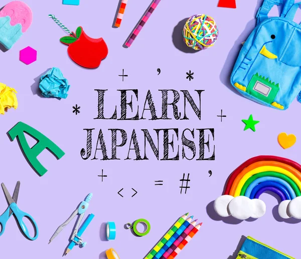 Learn Japanese theme with school supplies on a purple background - flat lay