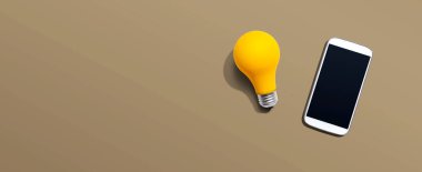 Yukarıdan sarı ampullü akıllı telefon.